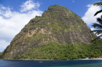 Val des Pitons The white sand beach at the Jalousie Plantation Resort Hotel with the volcanic plug of Petit Piton beyond and tourists on sunbeds beneath palapa sun shades