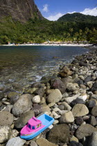 Val des Pitons The white sand beach at the Jalousie Plantation Resort Hotel with the volcanic plug of Petit Piton beyond and tourists on sunbeds beneath palapa sun shades with a childs plastic boat ma...