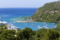Marigot Bay The harbour with yachts at anchor the and lush surrounding valley. The small coconut palm tree lined beach of the Marigot Beach Club sits at the entrance to the harbourCaribbean West Indi...