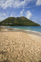 Reduit Beach in Rodney Bay during the early morning with tourists walking by the waterline