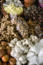 Market stall with local produce of herbs and spices including ginger  galangal  garlic and onions