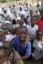 Tanji Village.  Happy  laughing children full of energy and wanting to be photographed  trying to get the best position while on a break from lessons at the Ousman Bun Afan Islamic school. TanjehTan...