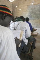 Tanji Village.  Muslim boys writing in arabic at their desks while attending an islamic religious class at the Ousman Bun Afan Islamic school.  Blackboard on wall in front of them. TanjehTanjihAfri...