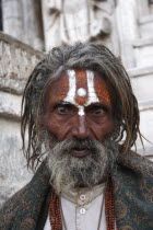 Head and shoulders portrait of elderly male Hindu beggar in front of the Jagdish temple with painted forehead and wide eyed  fixed stare.CultureTraditionRaceRacialSilver CityCasteBelieverBelie...