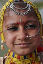 Portrait of a young Indian girl at Meherangarh Fort wearing nose ring and chain and traditional bead jewelery and black kohl eyeliner.jewellerydecorationculturecosmeticsbeautymake uppiercingAs...
