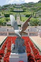 Zionism Avenue.  Eagle sculpture set in flower bed of scarlet plants at the Bahai gardens with view over tiered gardens stretching away beyond.sanctuarypilgimagesacredreligionmonothesistic faith...