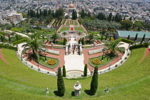 Zionism Avenue.  View of Bahai Shrine and Gardens built as memorial to founders of the Bah ai faith.  Formal layout of flowerbeds and pathways with cypress trees  central domed shrine and city beyond....