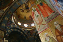 Nazareth.  Interior of the Greek Orthodox Church of St. Gabriel also known as the Church of the Annunciation  part view of domed roof and archways decorated with paintings of biblical scenes and the s...