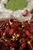 Jerusalem food market.  Open sacks of dried  red  hot chili peppers and green herbs.  Close cropped view filling frame.chillichilieschilliescapsicumfruitvegetablespicetastecookcookingcuisin...