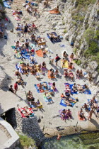 Tricase.  Looking down on people sunbathing on coloured beach towels laid out on rocks next to the sea.ApuliasunSummerholidayvacationtourismBeaches Colored European Holidaymakers Italia Italian...