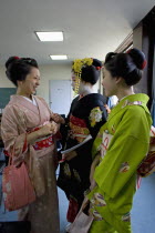Gion area.  Three Maiko or apprentice geisha wearing kimonos  talking and laughing after finishing their classes at Mia Garatso school for Geisha and Maiko.Far EastGeikotraditioncultureJapanesec...
