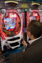 Shinjuku.  Japanese man gambling at electronic machinegamesgamblerelectricmodern lifecultureFar Eastcountry of the rising sunAsia Asian Male Men Guy Nihon Nippon One individual Solo Lone Solit...