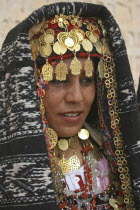 Head and shoulders portrait of Tunisian bride wearing traditional dress  gold jewelry and decorated head dress in preparation for her wedding held on the edge of the Sahara Desert.marriage  ceremony...