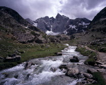 Upper Vallee de Gaube.  Fast flowing river tumbling over rocks in mountain landscape with central peak and north face of Vignemale 3298 m high  south of Pont d Espagne.