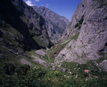 View north down Arroyo del Tejo Valley from Bulnes El Castillo with steep sided  eroded limestone cliffs and narrow  winding mountain path.