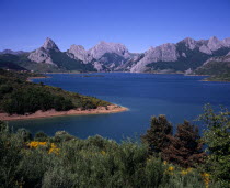 Landscape with man-made lake and mountain range beyond with Mt. Gribo on left 1675 m / 5486 ft.