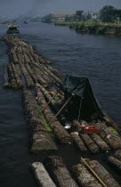 Log rafts on the Grand Canal between Suzhou and Wuxi. Men sheltering under a tent on logs.Asia Asian Chinese Chungkuo Jhonggu� Zhonggu� Male Man Guy