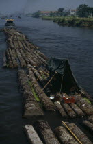 Log rafts on the Grand Canal between Suzhou and Wuxi. Men sheltering under a tent on logs.Asia Asian Chinese Chungkuo Jhonggu Zhonggu Male Man Guy