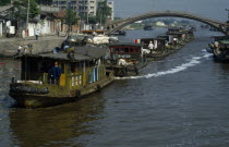 Barge train travelling down the Grand Canal under bridge between Suzhou and Wuxi. Asia Asian Chinese Chungkuo Jhonggu Zhonggu Traveling