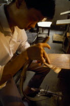 Man hand cutting with saw sandalwood fansAsia Asian Chinese Chungkuo Jhonggu Zhonggu Male Men Guy One individual Solo Lone Solitary
