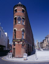 Bittles Bar  brick exterior facade  A-board advertising menu and beer barrels at side with the Albert Memorial Clock Tower seen beyond.Bal Feirste Eire European Inn Irish Northern Europe Pub Republi...