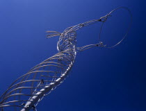 Oxford Street.  Angled view of modern metal sculpture from low viewpoint looking up  depicting female figure holding up hoop against cloudless blue sky.Bal Feirste Eire European Irish Northern Europ...