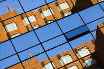 Modern apartment block reflected in windows of office blockIreland Eire Patterns Architecture Construction
