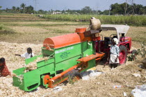 Farm labourers processing corn cobs on a type of threshing machine to remove leavesSouthSouthernIndiaIndianAsiaAsianFarmFarmingFarmerHorizontalOutsideOutdoorAgricultureAgriculturalAdult...