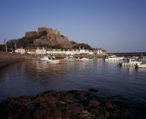 Grouville. Gorey Castle or Mont Orgueil set on hill overlooking village buildings and boats in harbour with the tide in. On the east coast.European Scenic Castillo Castello Northern Europe