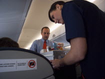 Cabin crew dispensing drinks and snacks during flight.Holidaymakers Tourism Tourist