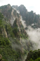 Huangshan or the Yellow Mountain. Rock peaks with lush green pine trees and a sea of cloud. Has inspired countlless painters and poets over the ages and has a 1200-year history as a tourist attraction...