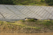 Stone lining the Yangtze River embankment near Wushan with satellite TV dish by workers temporary living quartersAsia Asian Chinese Chungkuo Jhonggu Zhonggu Ecology Entorno Environmental Environnem...