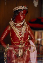 Red statue of Jesus Christ used in Umbanda ceremonies adorned with pearl necklaces and gold jewellery . A Yoruba Christian cultAmerican Brasil Brazilian Jewelry Latin America Latino Religion Religion...