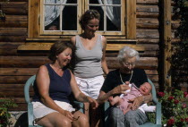 Group portrait of four generations of the Fossgard family including mother  grandmother and great grandmother holding new baby in Norway4 Babies European Grandma Granny Mum Noreg Norge Northern Europ...