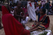 Punnaccolai Festival. Hindu Tamil Priest wearing a red robe performing a curing / healing Puja on a woman Asia Asian Female Women Girl Lady Llankai Performance Religion Religious Hinduism Hindus Sri...