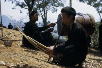 Meo men playing musical instruments during the traditional ox killing ritual Meo indigenous peopleAsian Classic Classical Historical Indegent Lao Male Man Guy Older Southeast Asia