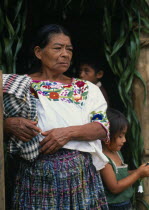 Q eqchi Indian grandmother wearing a traditional embroidered blouse standing with children in a Sacaak refugee settlementIndigenous people American Central America Classic Classical Grandma Granny Hi...