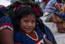 Portrait of a young Quiche Indian girl sitting on her mothers knee smilingAmerican Central America Happy Hispanic Immature Kids Latin America Latino