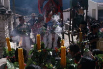 Quiche Indian women holding candles facing Confradia brotherhood and Saints during San Andres Festival on December 8thAmerican Central America Female Woman Girl Lady Hispanic Latin America Latino Rel...