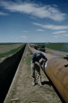 Constructing Trans Canada gas pipeline over Saskatchewan Prairies. A worker called Mr E Thompson weldingAmerican Canadian North America