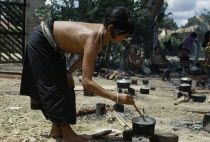 Vietnam War. Montagnard village. Refugee woman cooking rice in a pot on small open fireKon TumAsian Southeast Asia Viet Nam Vietnamese Female Women Girl Lady