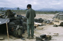 Vietnam War. Siege of Kontum. Montagnard soldiers in camp with sand bags and makeshift shelters Kon TumAsian Southeast Asia Viet Nam Vietnamese