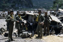 Meo soldiers gathered around a damaged plane in Ban Xon Airport carrying armour and wearing uniform with yellow scarves.WarAsian Lao Southeast Asia Armor