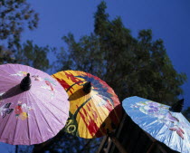 Bor Sang Umbrella and Sankampaeng Handicraft Festival.  Blue  yellow and purple umbrellas painted with flowers  butterflies and sunset.  For more than 100 years Bor Sang village has been associated w...