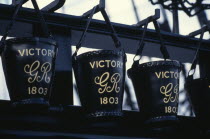 HMS Victory.  Detail of black leather buckets hanging from row of metal hooks.European Great Britain History Northern Europe UK United Kingdom