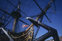 Admiral Lord Nelson s HMS Victory in Portsmouth s Historic Dockyard. Angled view of bow of ship with figurehead  Union Jack flag and large anchor in the foreground.European Great Britain History Nort...