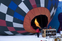 Flame being directed into inflated Hot Air Balloon to heat air inside. European Schweiz Suisse Svizzera Swiss Western Europe Winter Snow Festivals International Balloon Festival Guangzhou One individ...