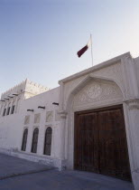 Doha Fort.  Exterior view showing ornate doors with the Qatar flag flying above.Inside are exhibitions of Qatari life. Learning Lessons Middle East Teaching