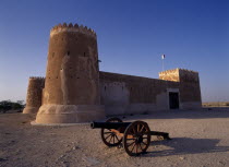 Exterior view of a fort with crenellated towers  built in 1938 and used as a police border post  now a museum.  A cannon in the foreground.   History Middle East Qatari