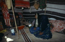Bedouin girls sitting inside tent decorated with hanging textiles weavingshelter Cloth Kids Middle East Qatari
